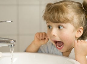 child flossing teeth