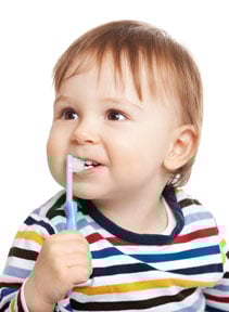 toddler using a toothbrush