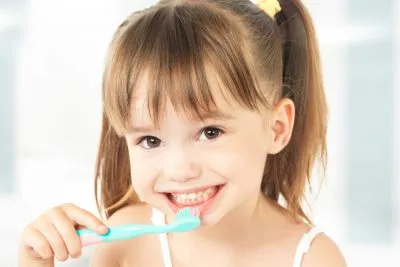 young girl using a toothbrush